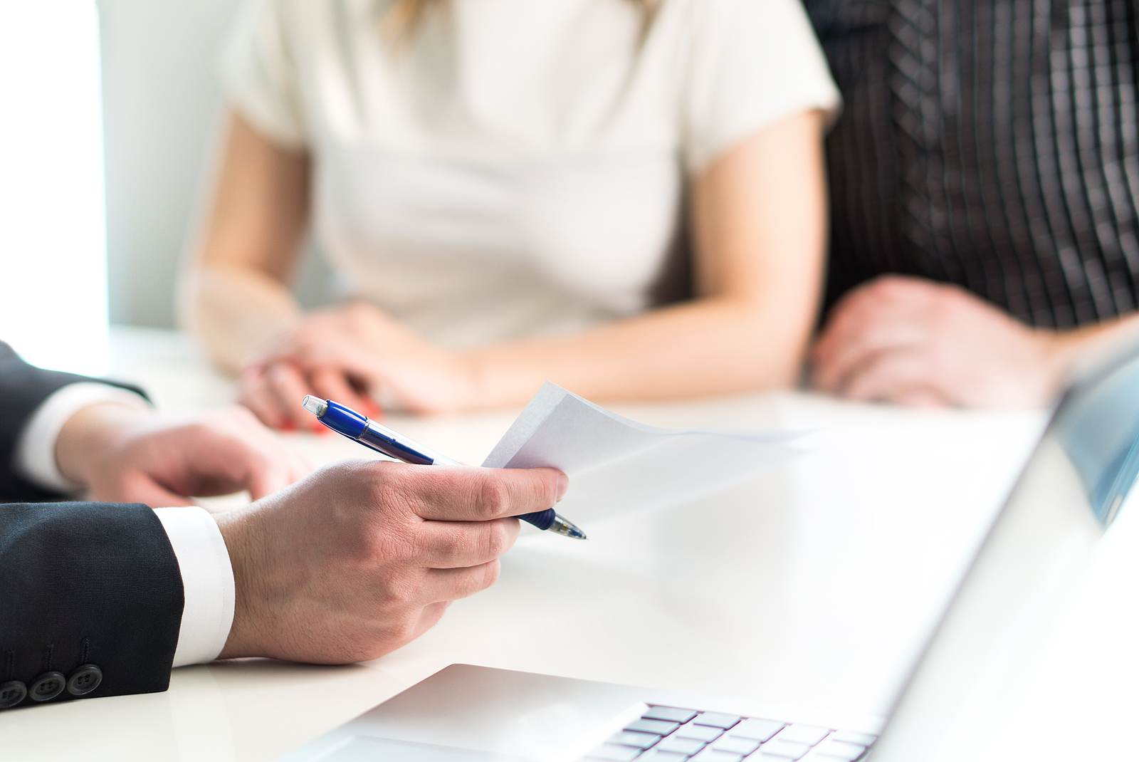 Lawyer reviewing legal documents with a couple during a meeting.